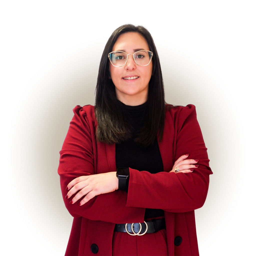Advogada Carolina Bucete Oliveira a sorrir de braços cruzados, com um fato vermelho vestido.